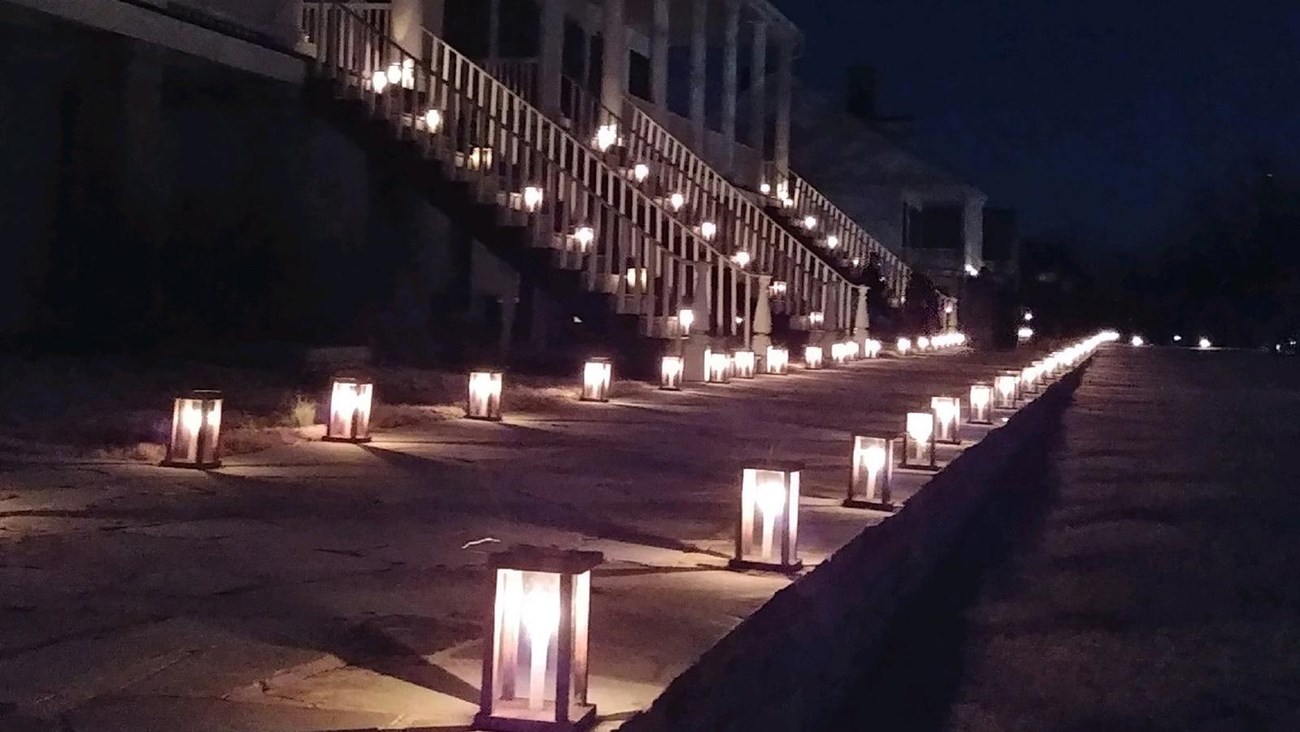 Candle lanterns lighting the Officer's Row walkway at night.
