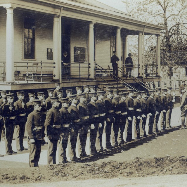 Historic photograph of soldiers standing in front of a building at Vancouver Barracks