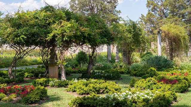 Overgrown gardens with statuary and paths.
