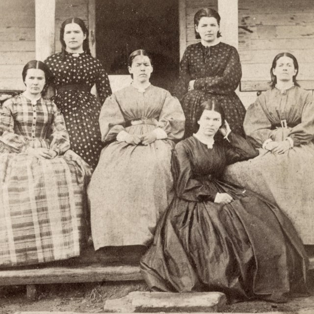 Six women sitting on a porch during the Civil War.