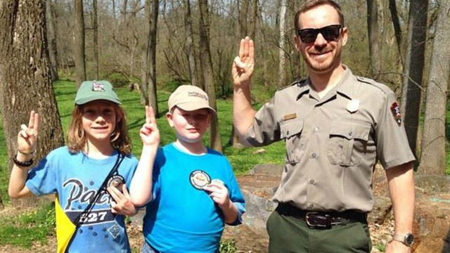 Park Superintendent poses with a Girl Scout and a Boy Scout. 