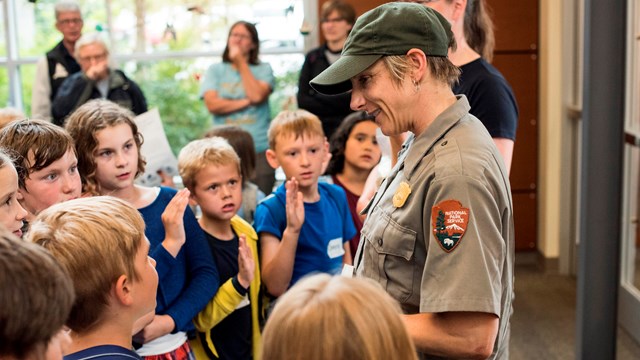 Students gather around a park ranger. 