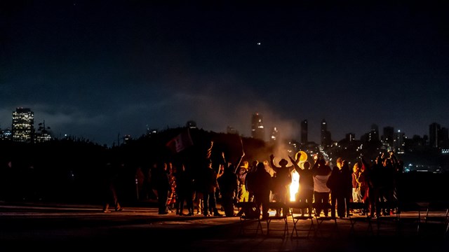 People gather around fire at night time on Alcatraz