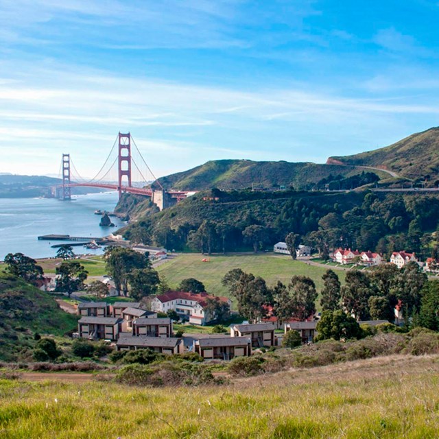 Buildings of Fort Baker nestled in the hills of the foreground, Golden Gate bridge & SF Bay behind