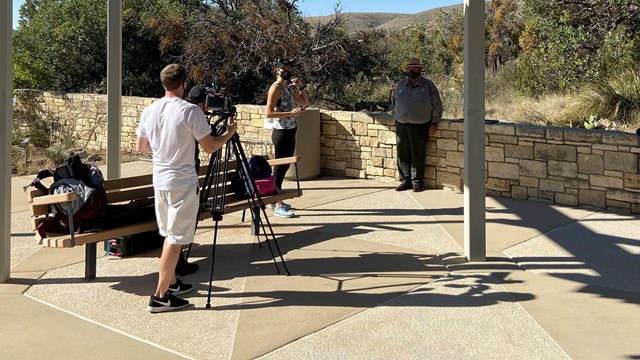 A film crew and journalist interviews a park ranger