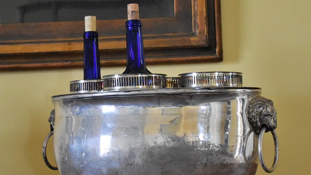 A silver wine cooler with two wine bottles inside. 