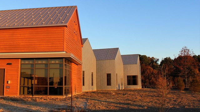 Sunrise reflecting on the exterior of a brown and gray visitor center