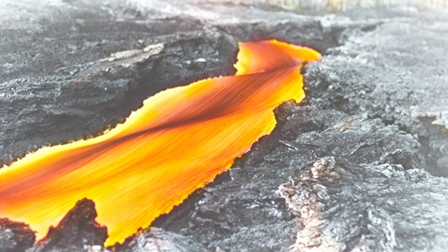 Historic photograph of a channelized river of molten lava. 
