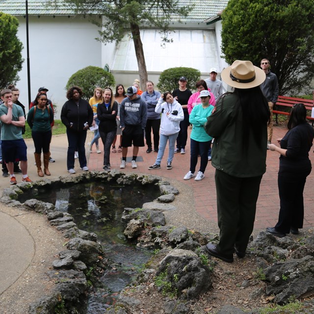 A female ranger delivers a program near one of the thermal springs.