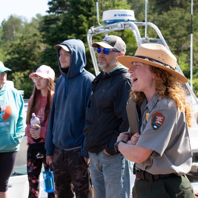 A park ranger talking with visitors on a dock.