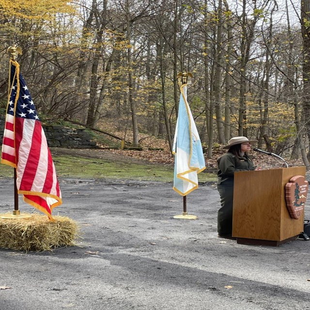 A park ranger at a podium during a press conference. 