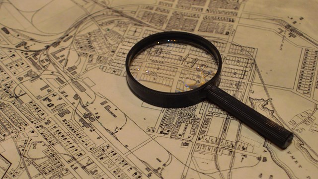 An image of a magnifying glass sitting on top of a historic map