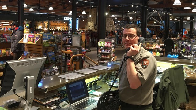 Ranger answering phone in the middle of a retail space. 