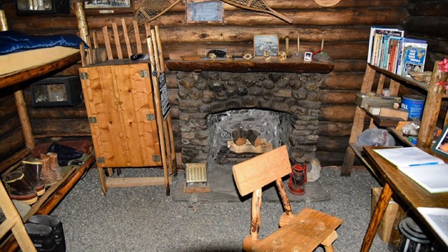 the inside of a wooden cabin with a fireplace