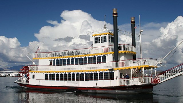 A large paddlewheel boat on a body of water.