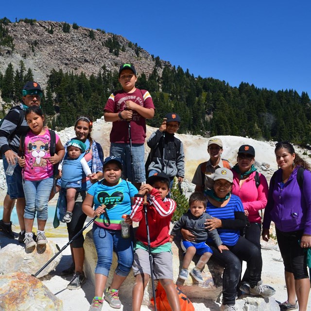 A group of adults and children in a hydrothermal area.