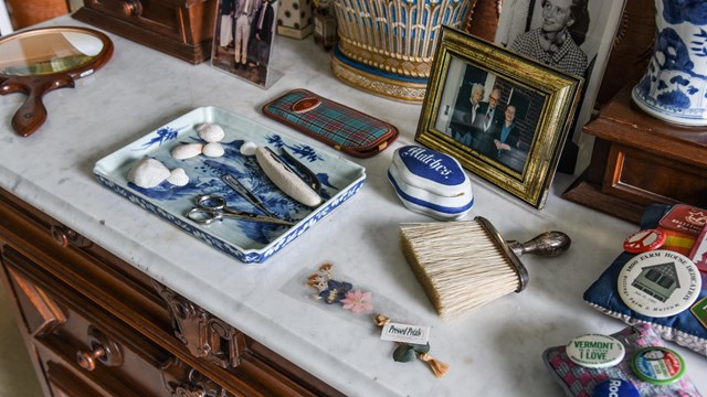 Close up of the top of a historic dresser with personal objects and family photos