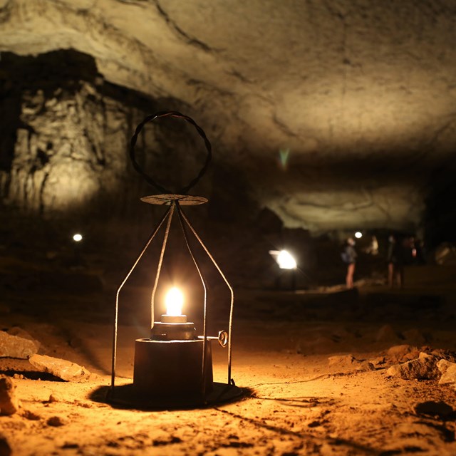 A lit oil lantern in a cave passage.