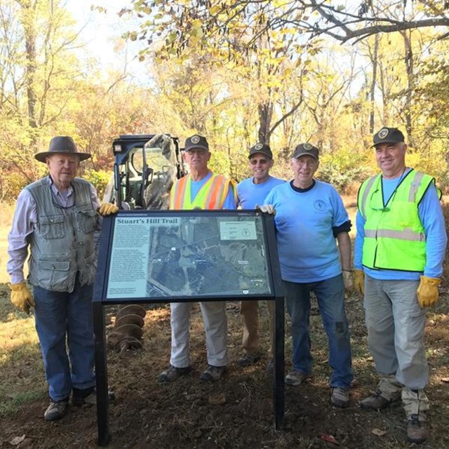 Group of volunteers standing next to an installed wayside panel