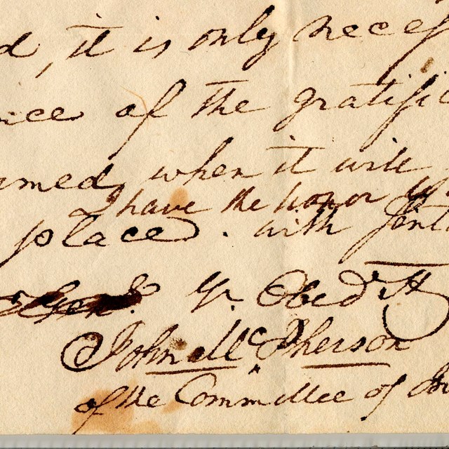 Close up of a letter written in old script with the signature of Col. John McPherson.