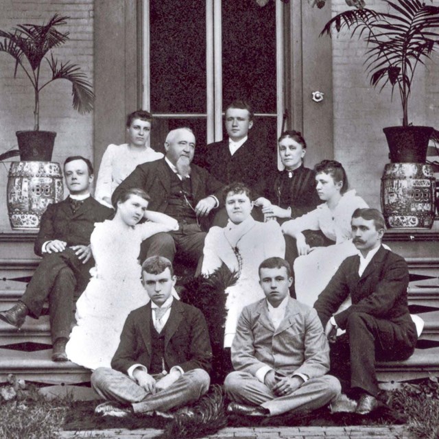 The Gambrill family seated on the steps of their home.