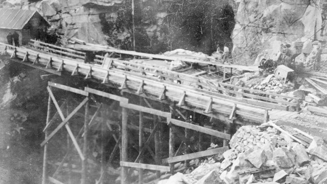 A bridge and road over a canyon under construction and surrounded by wood scaffolding.  