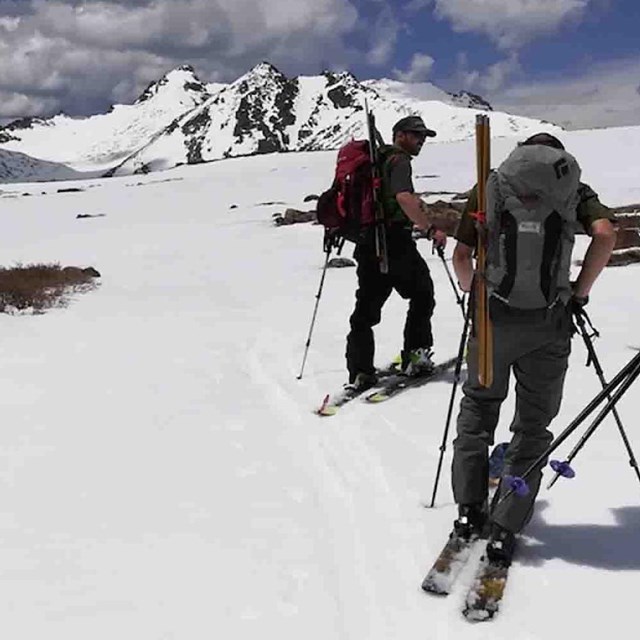 A research team skies on a mountain ridge.