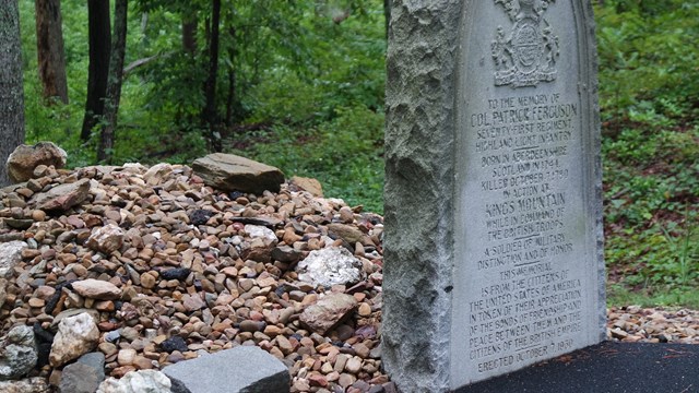 A stone marker beside a paved trail in the forest