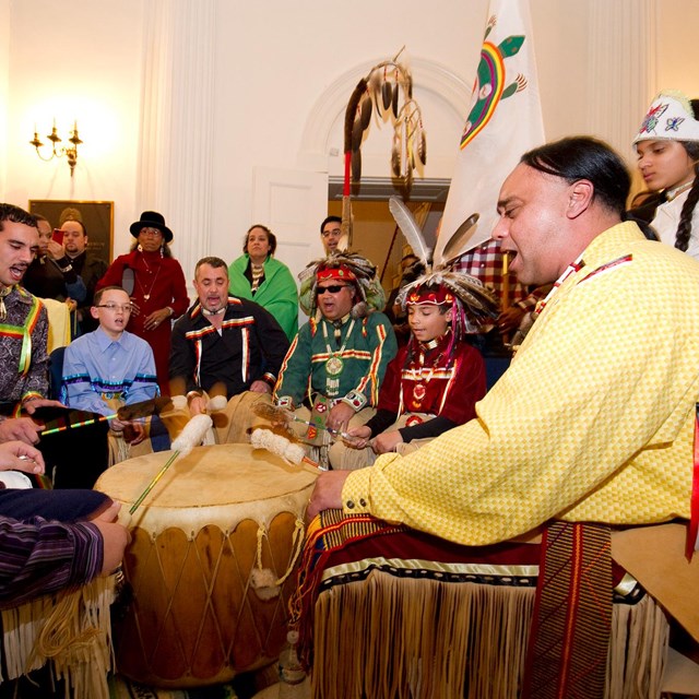 a group of native Americans in a drum circle