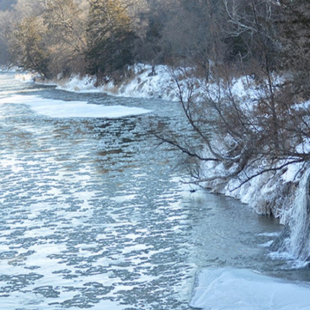 Ice covered Niobrara River flows along snowy banks. Crediy:  Kristen Maxfield