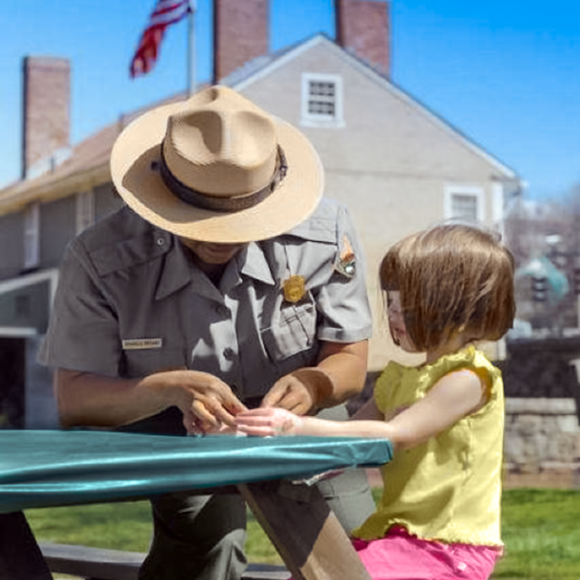 Image of a park ranger with a young Junior Ranger