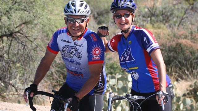 two cyclists stop to smile for a photo