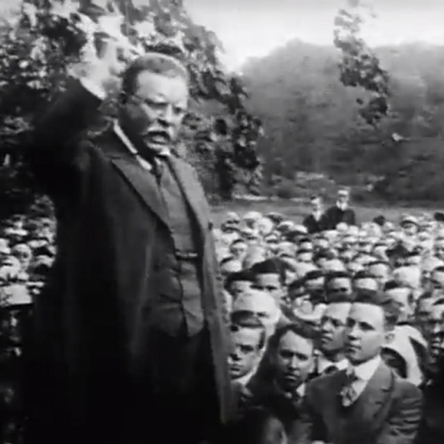 Theodore Roosevelt speaking to a large crowd from the porch of Sagamore Hill.