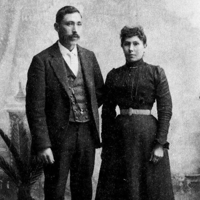 Black and white photo of a man and his wife in a portrait studio