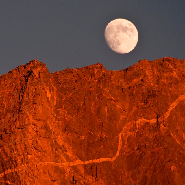 The moon over an alpine peak