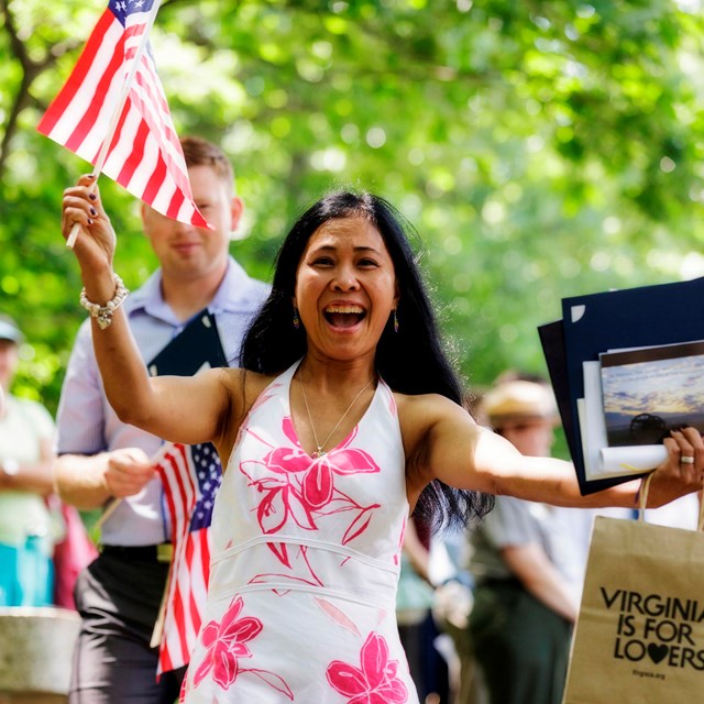 Woman holding flag at a naturalization ceremony.