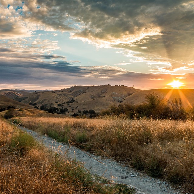 Sunset and an active sky over a rolling mountain landscape