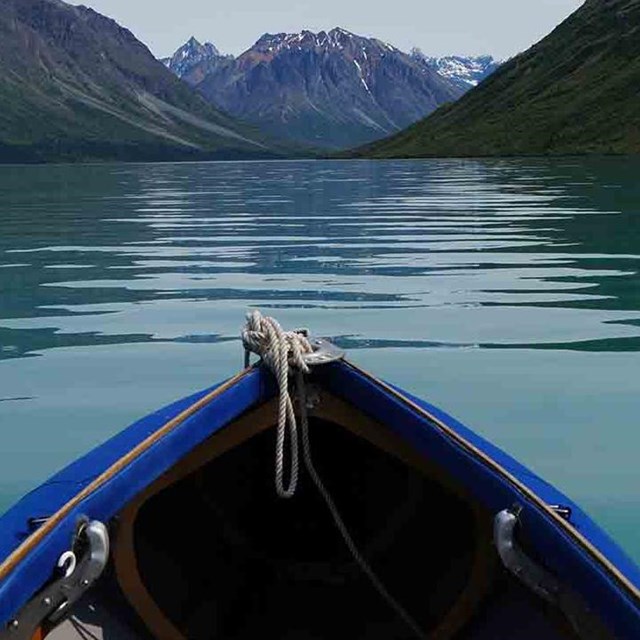 The bow of a kayak pointing toward the mountains.