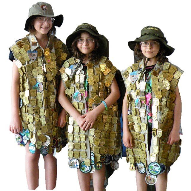 Photograph of three female junior rangers adorned with junior ranger badges.