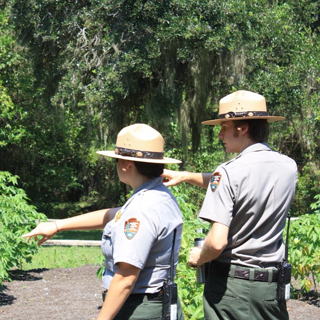 two rangers standing in a garden pointing