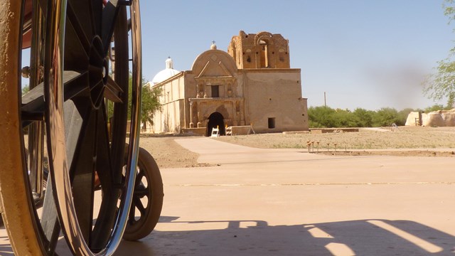 wheelchair and paved trail in foreground with church in background
