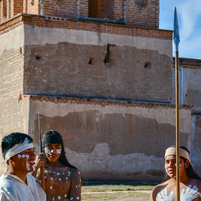 native people in paint and dress in front of church