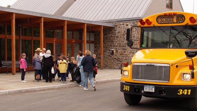 Students exiting a school bus at the visitor center.