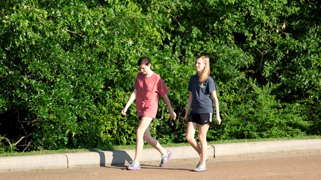 2 women walk the park tour road