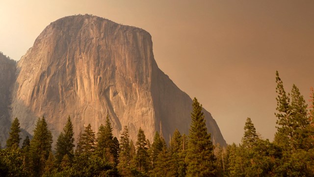 El Capitan rises through smoke from a wildfire