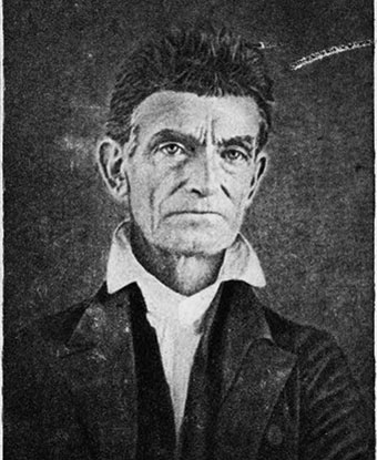 black and white image of John Brown; he&#39;s clean shaven; wearing a white collared shirt and dark coat