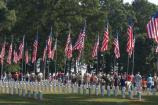 Volunteers gather to begin placing flags on graves in the National Cemetery at Andersonville National Historic Site