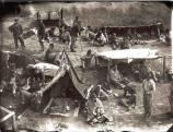 Living history recreation of a historic scene at Camp Sumter with prisoners and shelters.