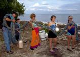 A family helps remove some of the many tons of trash that wash onto Biscayne's shorelines every year.