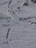 aerial image of snowy landscape, dirt road covered by thick ice